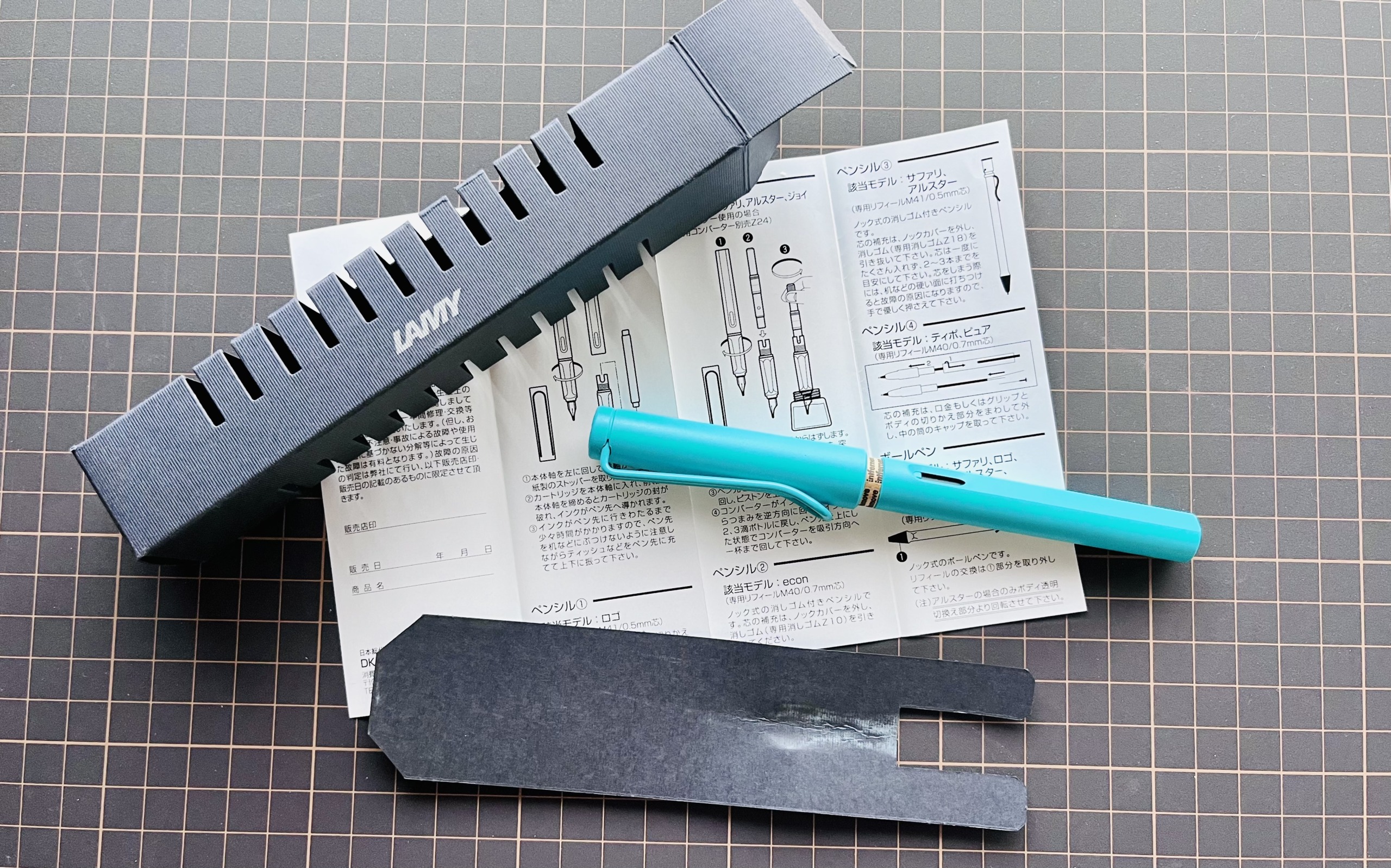 パッケージと説明書、下はペン本体を固定するためのストッパー。